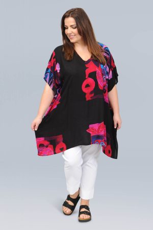 The model in this photo is wearing an Angel Circle square poncho in a funky abstract pink on black print from Bakou London