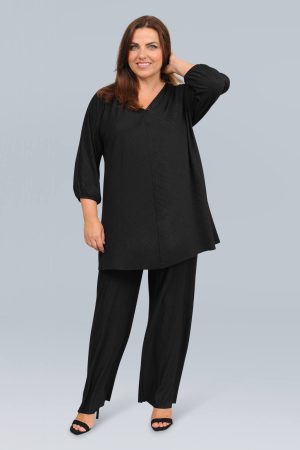 The model in this photo is wearing an elegant and luxurious plisse v neck tunic top by plus size specialists See You at Bakou London