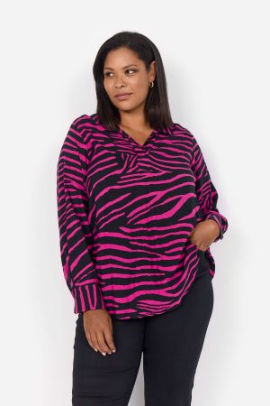 The model in this photo is wearing a Wasabi Concept Kenja 2 animal print tunic in plus sizes at Bakou London